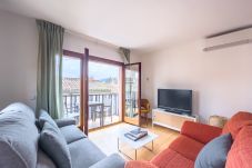 Un apartamento luminoso en Banyoles con un acogedor salón, grandes ventanales y un balcón privado con asientos.  