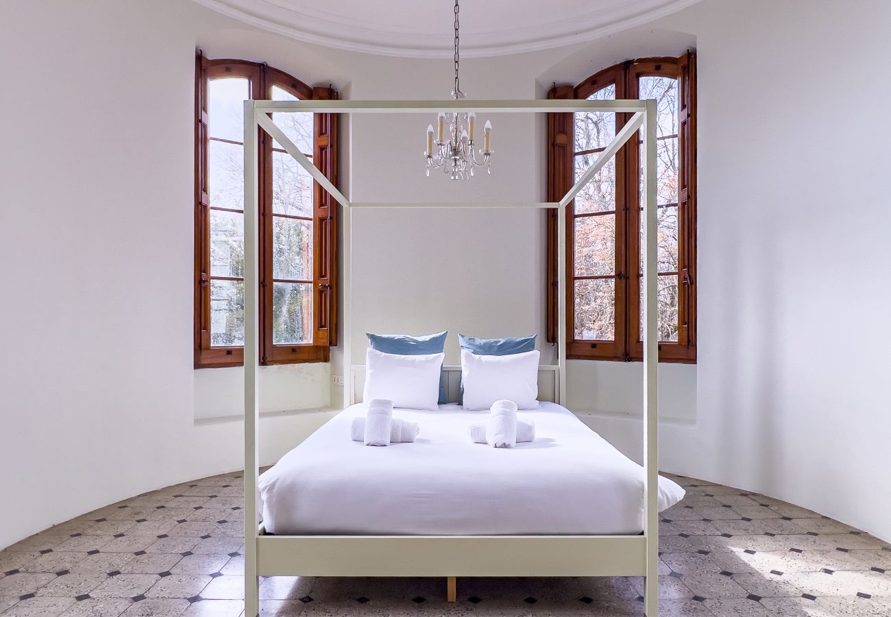 Tower bedroom with canopy bed and 180-degree forest views in a Girona castle