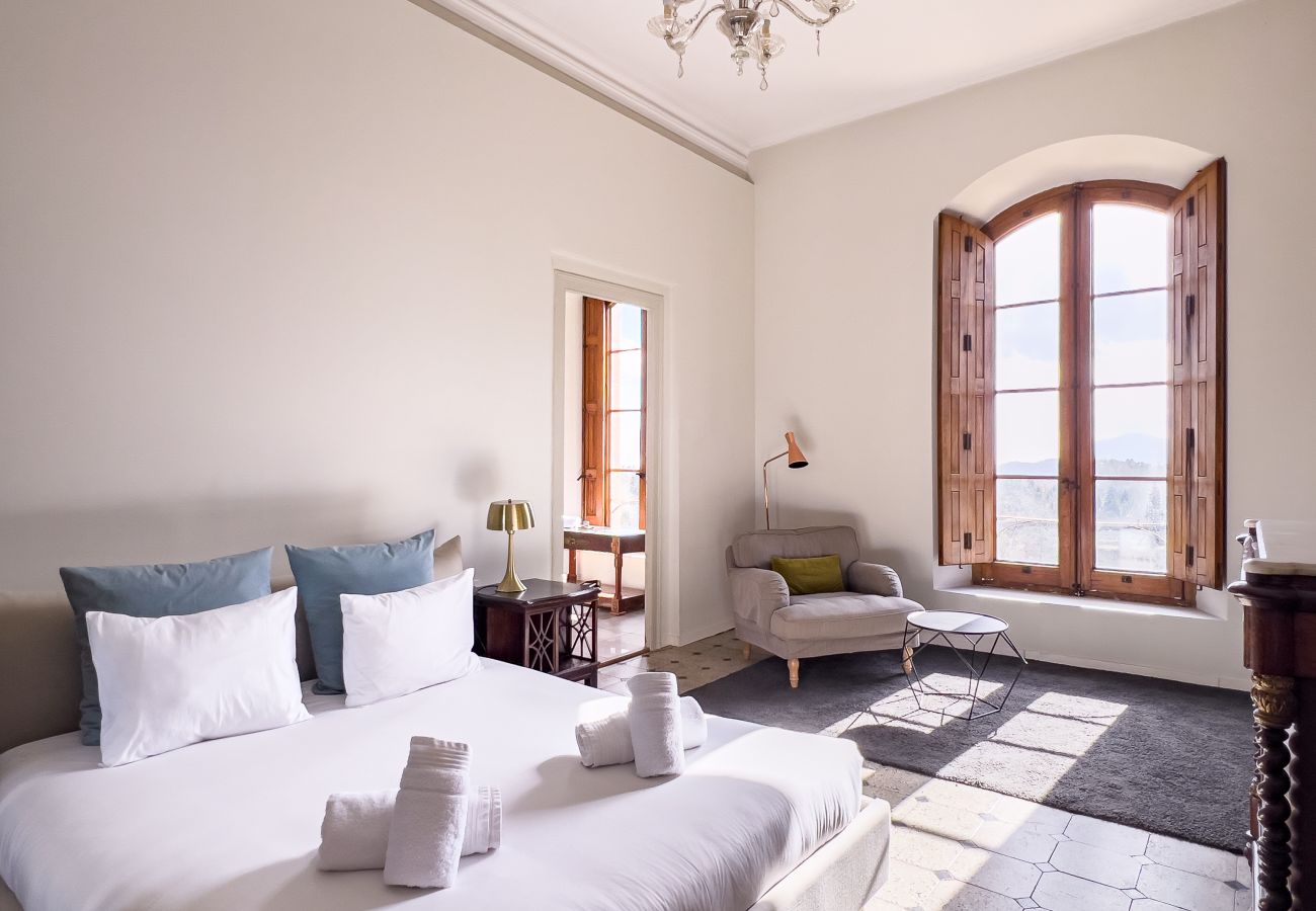 Double bedroom with marble fireplace and pool views on the first floor of a Girona castle