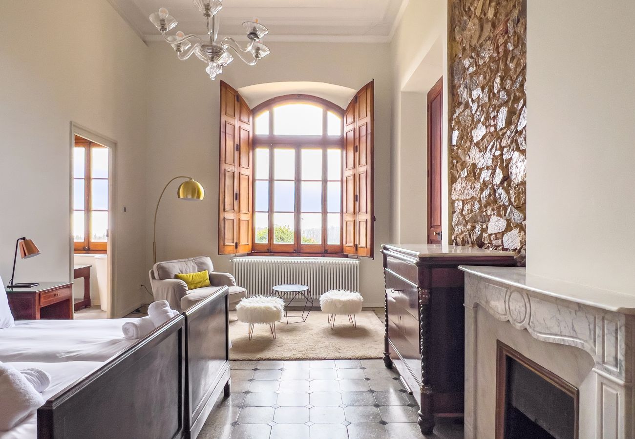 Chambre twin avec cheminée en marbre et fenêtre arquée dans un château de Gérone