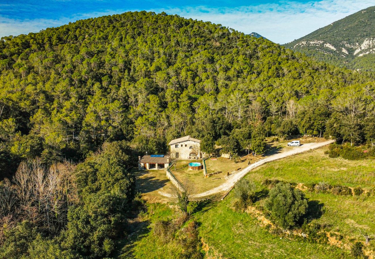 Stenen huis op een heuvel met zwembad bij Rural holiday home El Molí in La Garrotxa, omringd door een dicht bos